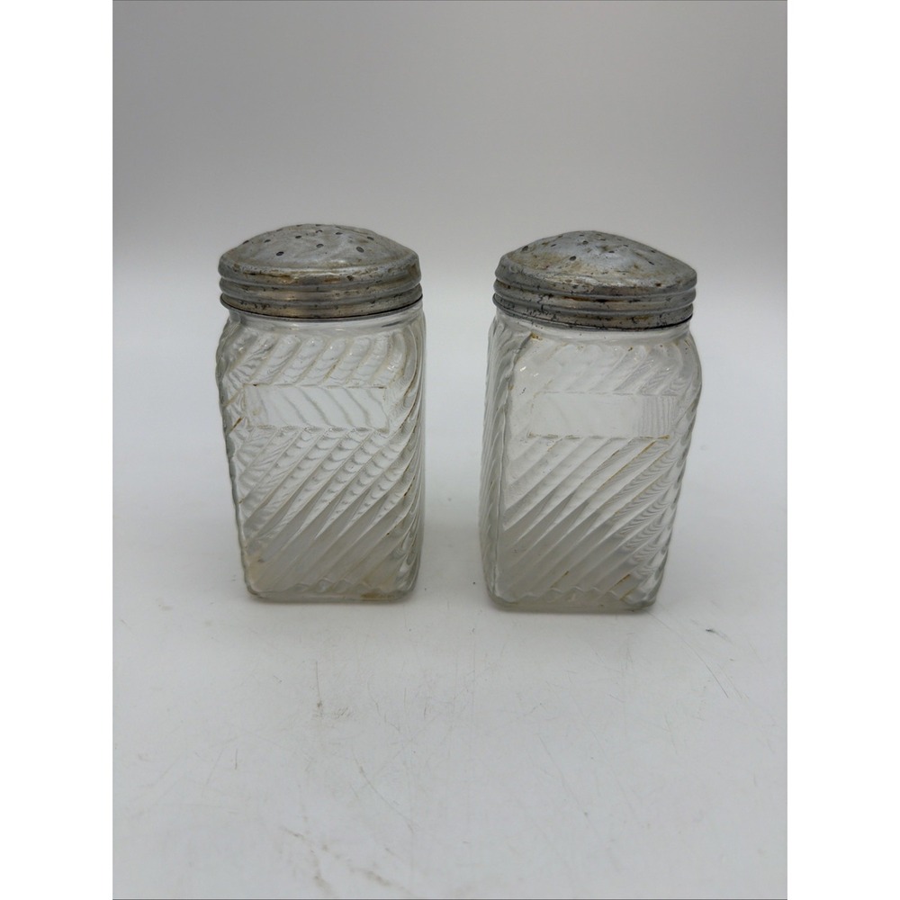 shows a pair of vintage 1930s clear glass spice or range shakers